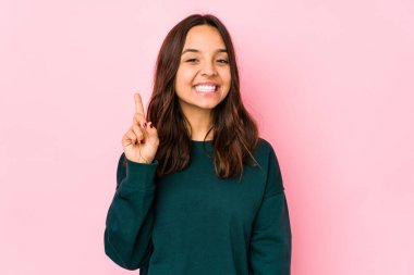 Genç, melez, Latin bir kadın bir numarayı parmağıyla gösteriyor..