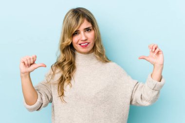 Sarışın, beyaz bir kadın baş parmağını aşağı gösteriyor ve hoşlanmadığını söylüyor..