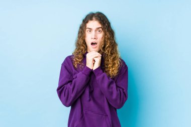 Uzun saçlı adam yalnız poz veriyor şans diliyor, hayret içinde ve ağzı açık..