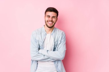 Beyaz arka planda poz veren Kafkasyalı genç iş adamı yalnız gülüyor ve eğleniyor..