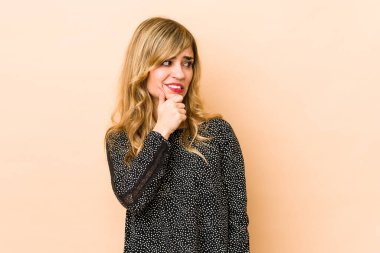 Sarışın, beyaz bir kadın başının arkasına dokunuyor, düşünüyor ve bir seçim yapıyor..