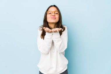 Genç, melez, İspanyol bir kadın. Dudaklarını katlayıp, avuç içlerine hava öpücüğü yolluyor..