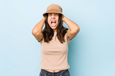 Genç, melez, İspanyol bir kadın. Kulaklarını ellerinle kapatıyor. Gürültülü sesler duymamaya çalışıyor..