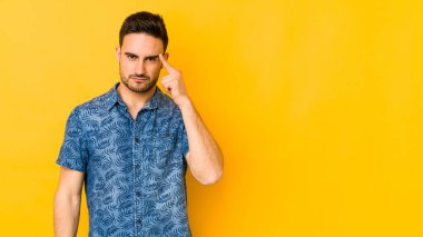 Kafkasyalı genç adam sarı fırında izole edilmiş, parmağıyla tapınağı işaret ediyor, düşünüyor ve bir göreve odaklanıyor..