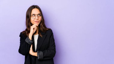 Latin kökenli genç bir kadın şüpheli ve şüpheci bir ifadeyle yanlamasına bakıyor..