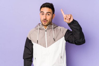 Mor arka planda soyutlanmış genç beyaz bir adam. Yaratıcılık kavramı hakkında harika bir fikri var..