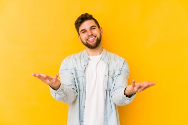 Sarı arka planda izole edilmiş beyaz bir genç hoş bir yüz ifadesi sergiliyor..