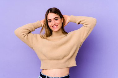Mor arka planda izole edilmiş genç beyaz kadın kollarını uzatıyor, rahat pozisyonda..