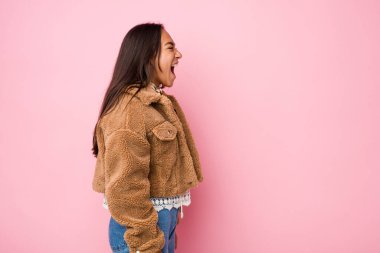 Koyun derisi paltosu giymiş genç Hintli kadın fotokopi alanına doğru bağırıyor.