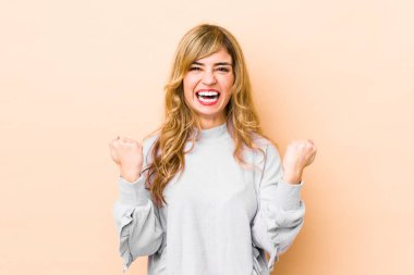 Genç sarışın, beyaz kadın, gamsız ve heyecanlı bir şekilde tezahürat yapıyor. Zafer konsepti.