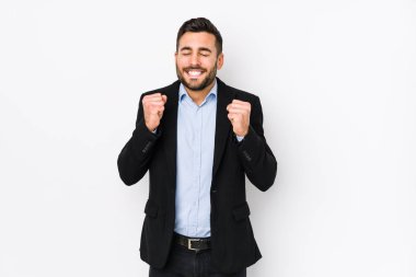 Beyaz bir arka plan karşısında beyaz tenli genç bir iş adamı kendini mutlu ve başarılı hissediyordu. Zafer konsepti.
