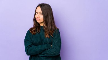 Latin kökenli genç bir kadın hoşnutsuzca kaşlarını çatmış, kollarını kavuşturmuş..