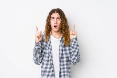 Genç, uzun saçlı adam yalnız poz veriyor. Ağzı açık, yukarı bakıyor..