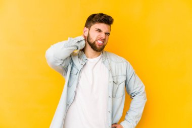 Sarı arka planda izole edilmiş genç beyaz adam sabit yaşam tarzından dolayı boyun ağrısından muzdarip..