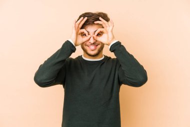 Bej bir arka planda izole edilmiş genç bir Arap, gözlerde sorun olmadığını gösteriyor.