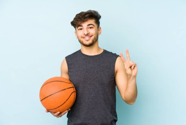 İki numarayı parmaklarıyla göstererek basket oynayan genç bir Arap..