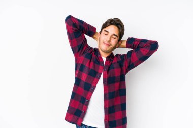 Pembe arka planda poz veren beyaz bir genç, izole edilmiş kollar, rahat bir pozisyon..