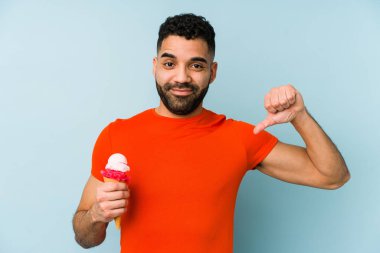 İzole edilmiş bir dondurma tutan genç latin adam gururlu ve kendinden emin, örnek olarak.