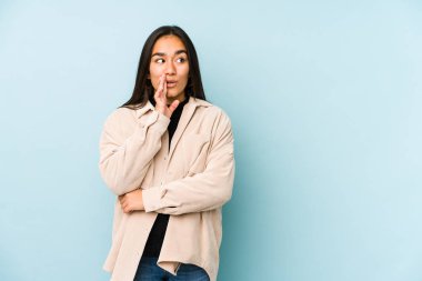 Mavi arka planda izole edilmiş genç bir kadın gizli bir sıcak fren haberinin olduğunu söylüyor.