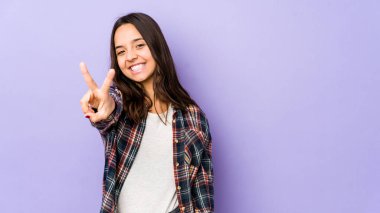 Genç melez İspanyol kadın zafer işareti gösteriyor ve gülümsüyor..