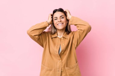 Kafkasyalı genç bir kadın yalnız kahkahalar atıyor ve ellerini başının üstünde tutuyor. Mutluluk kavramı.