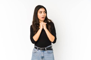 Mor arka planda izole edilmiş genç Hintli bir kadın şans için dua ediyor, şaşırmış ve ağzını açıp önüne bakıyor..