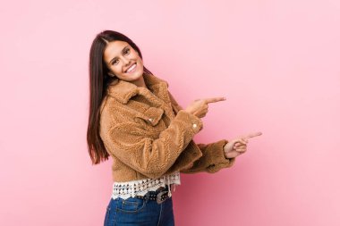 İşaret parmaklarıyla işaret ettiği için heyecanlanan genç ve tatlı bir kadın..