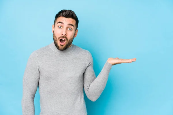 Young Caucasian Man Blue Background Isolated Impressed Holding Copy Space — Stock Photo, Image
