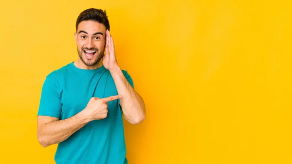 Joven Hombre Caucásico Aislado Campo Panadería Amarillo Tratando Escuchar Chisme — Foto de Stock