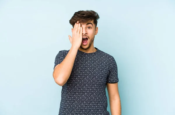 Jovem Árabe Homem Isolado Fundo Azul Divertindo Cobrindo Metade Rosto — Fotografia de Stock