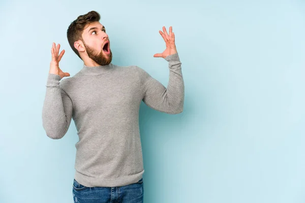 Ung Kaukasisk Man Isolerad Blå Bakgrund Skriker Till Himlen Tittar — Stockfoto