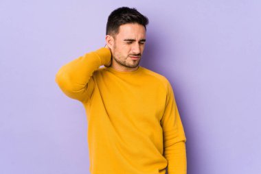 Mor arka planda izole olmuş genç beyaz bir adam stresten dolayı boynu ağrıyor, masaj yapıyor ve elle dokunuyor..