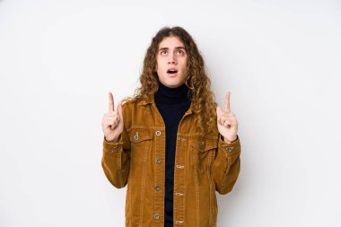 Uzun saçlı adam yalnız poz veriyor, ağzı açık bir şekilde yukarı bakıyor..