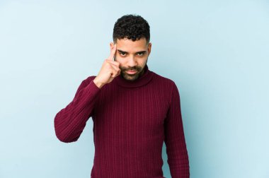 Genç, melez Arap bir adam, tapınağı parmağıyla göstererek, düşünerek, bir göreve odaklanmış..