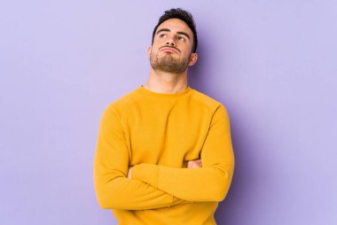 Mor arka planda izole edilmiş genç beyaz adam tekrarlanan bir görevden bıktı..