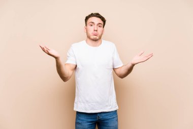 Kafkasyalı genç bir adam münzevi bir poz veriyor. Kuşkulanıyor ve omuz silkiyor..