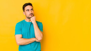 Kafkasyalı genç adam sarı fırında izole edilmiş. Rahatlamış bir şekilde bir şeyin fotokopi odasına baktığını düşünüyor..