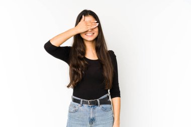 Mor arka planda soyutlanmış genç Hintli bir kadın elleriyle gözlerini kapatıyor, geniş bir gülümsemeyle bir sürpriz bekliyor..