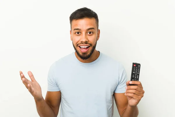 Joven Hombre Sudasiático Sosteniendo Controlador Televisión Recibiendo Una Agradable Sorpresa — Foto de Stock