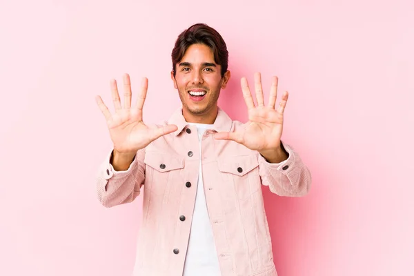 若いですCaucasian男Posingでピンクの背景単離されたショー番号10とともに手 — ストック写真