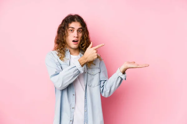 Mann Mit Langen Haaren Posiert Isoliert Aufgeregt Und Hält Kopierplatz — Stockfoto