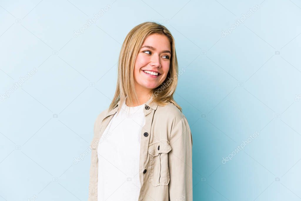 Young blonde caucasian woman isolated looks aside smiling, cheerful and pleasant.