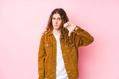 Genç, uzun saçlı, izole bir şekilde poz veren, hoşlanmadığı bir jest yapan adam. Anlaşmazlık konsepti.