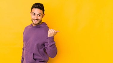Kafkasyalı genç adam sarı fırın noktalarında izole edilmiş, başparmak uzakta, gülüyor ve kaygısız..