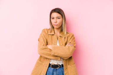 Kafkasyalı genç bir kadın hoşnutsuzca somurtuyor, kollarını kavuşturuyor..