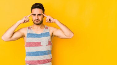 Sarı fırında izole edilmiş genç beyaz adam bir göreve odaklanmış, işaret parmaklarını işaret ediyor..