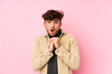 Arka planda poz veren genç bir Arap adam şans için dua ediyor, şaşırıyor ve önüne bakıyor..