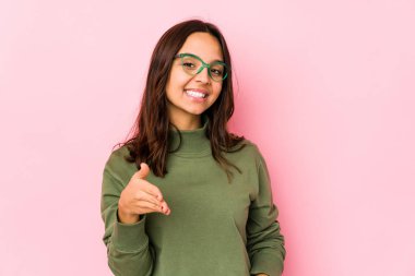 Latin kökenli genç bir kadın kameraya el uzatarak selam veriyor..