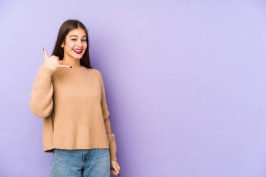 Mor arka planda izole edilmiş genç beyaz kadın parmakları olan bir cep telefonu hareketi gösteriyor..