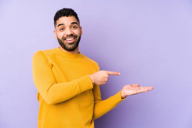 Genç, melez, Arap bir adam. Palmiye üzerinde bir kopya alanı tutarken heyecanlı..